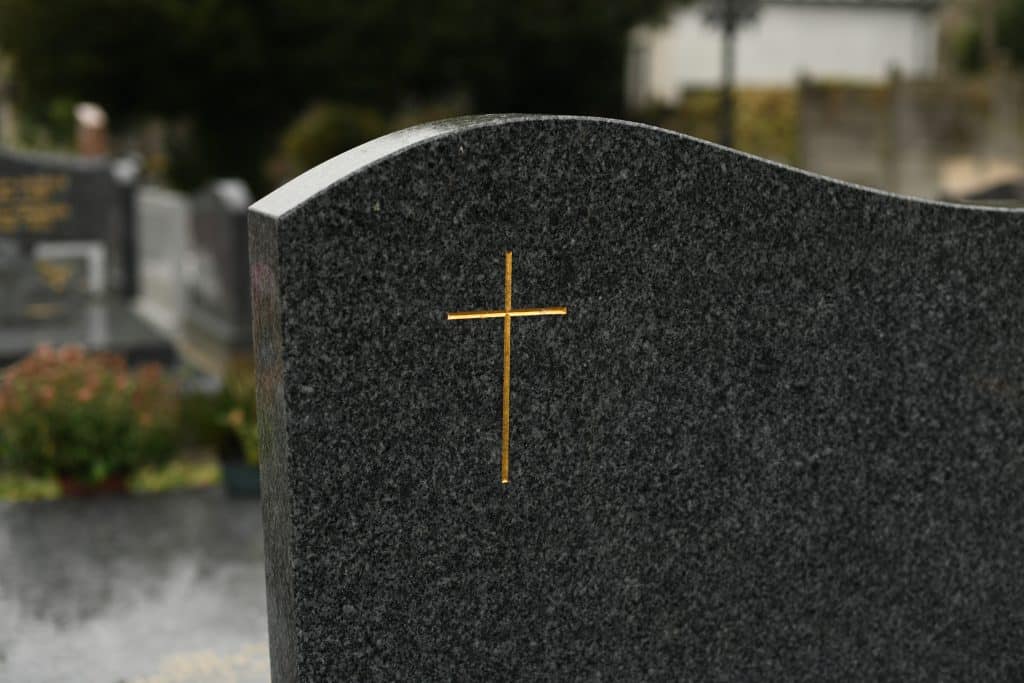 Grabstein mit einem goldenen Kreuz das grafiert ist